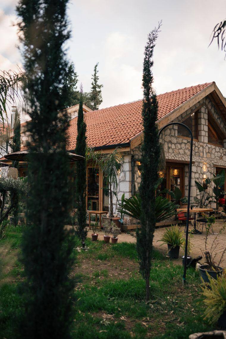 Selvilerin arasında kiremit çatılı taş ev