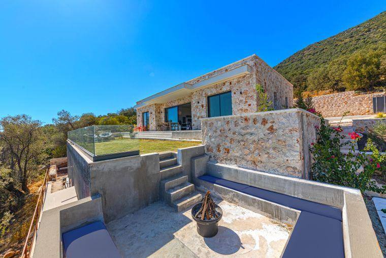 Yamaçtaki taş villa ve ateş çukurlu oturma alanı